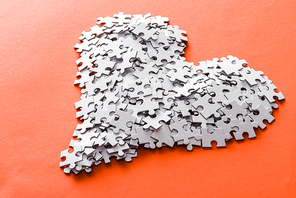 white heart-shaped jigsaw puzzle pieces on orange