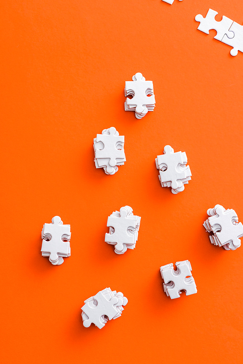 top view of stacks with white puzzle pieces on orange