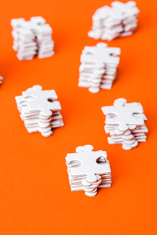 selective focus of stacks with white puzzle pieces on orange