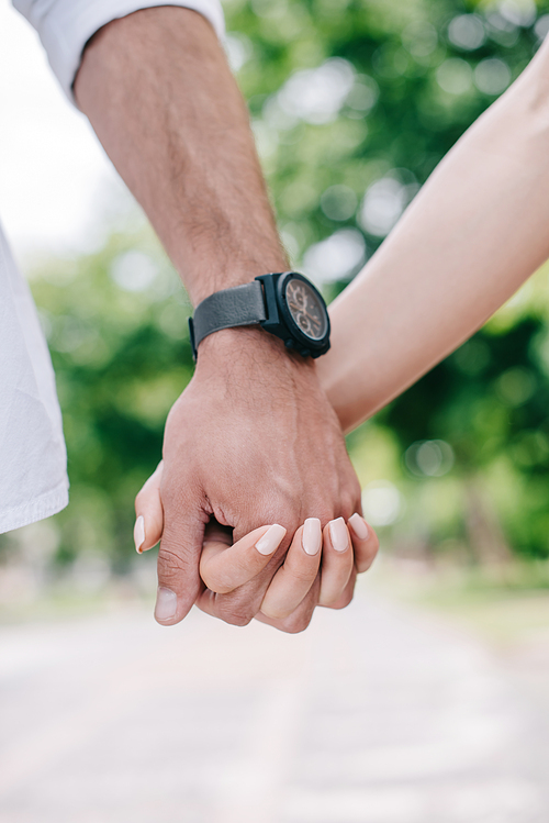 cropped view of man and woman holding hands
