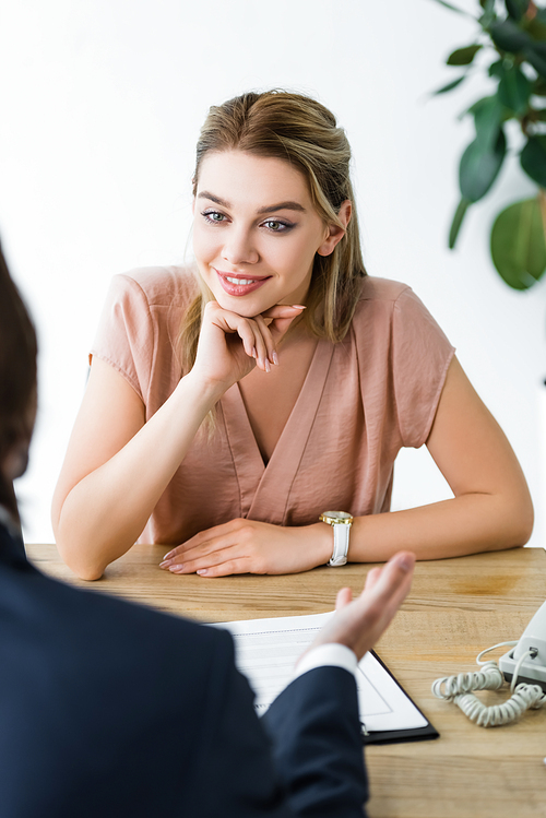 charming woman looking at businessman while sitting in office