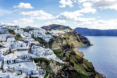 white houses near tranquil sea against sky with clouds in greece