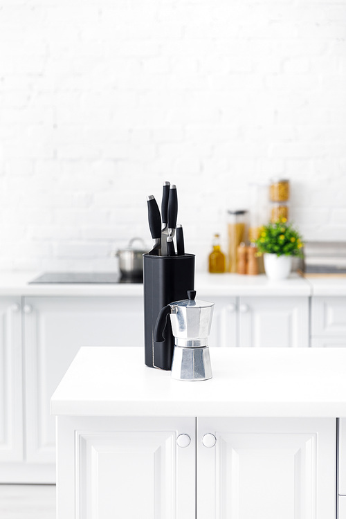 modern white kitchen interior with coffee pot and knives on table