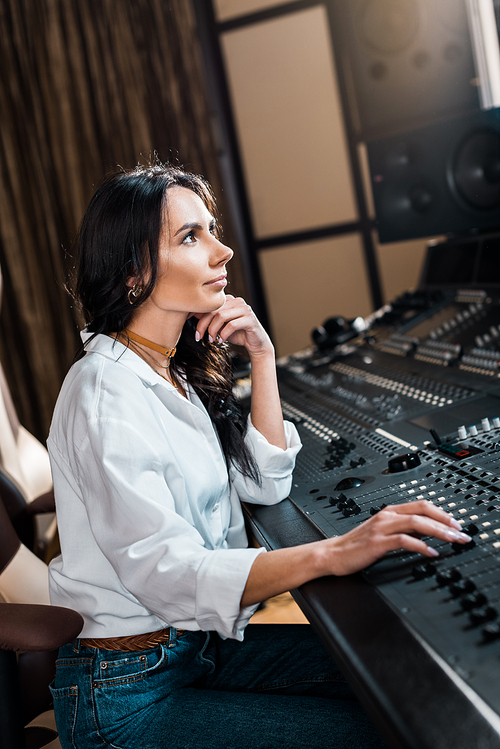 beautiful sound producer working on mixer console in recording studio
