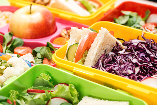 close up view of tasty food in lunch boxes