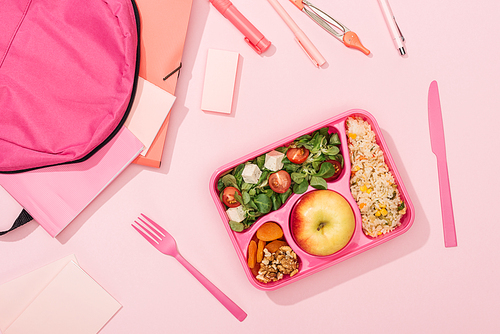 top view of lunch box with food near backpack and stationery