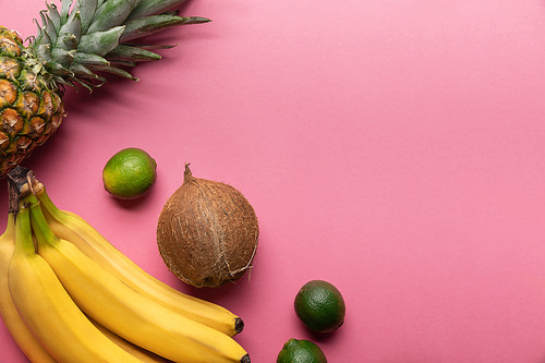 top view of ripe tropical bright fruits on pink background with copy space