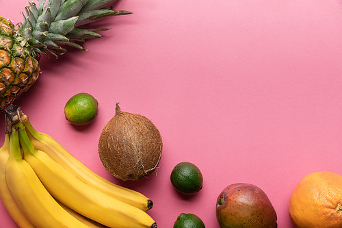 top view of ripe tropical fruits on pink background with copy space