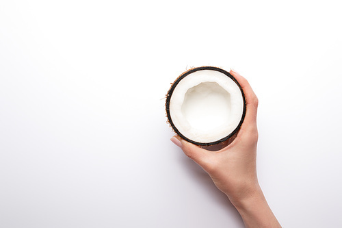 cropped view of woman holding ripe coconut half on white background with copy space