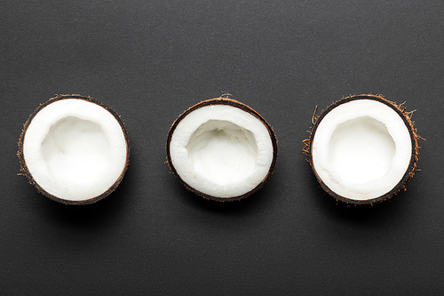 top view of coconut halves on black background