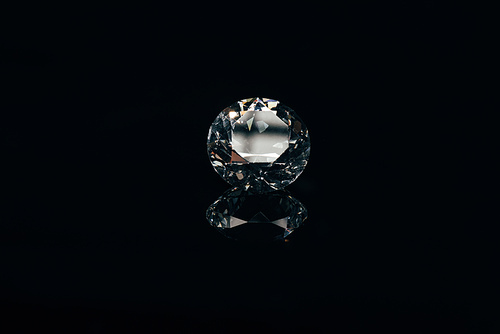 transparent pure sparkling diamond isolated on black with reflection