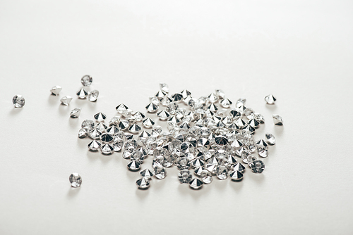 transparent pure small diamonds scattered on white background