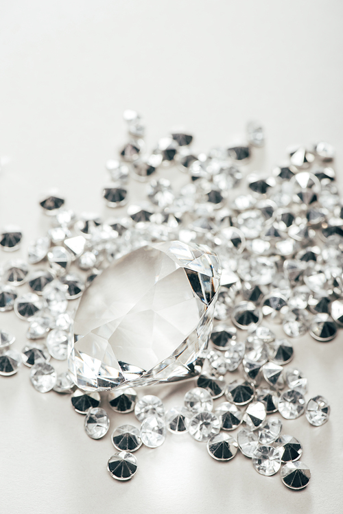 selective focus of transparent pure big diamond among small on white background