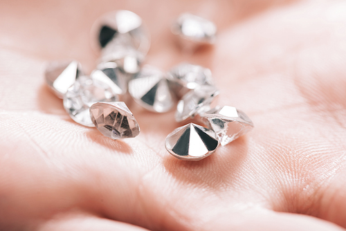 close up of shiny small pure diamonds in hand