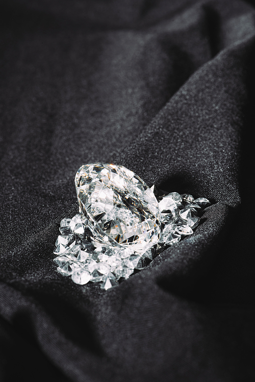 pile of shiny pure diamonds on black textured cloth