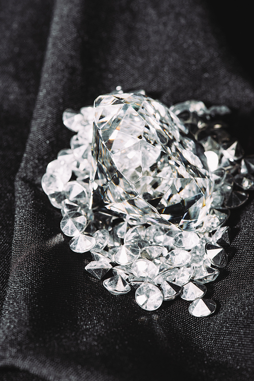 pile of sparkling pure diamonds on black shiny cloth