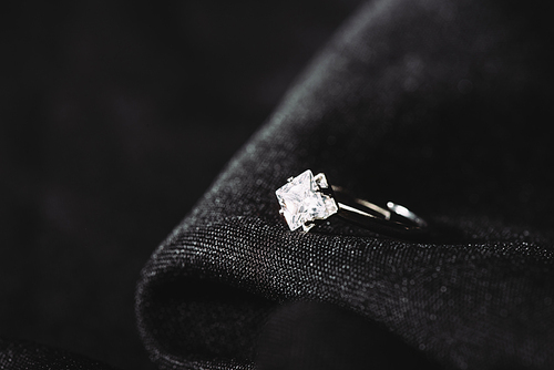 engagement ring with pure shiny diamond on black cloth