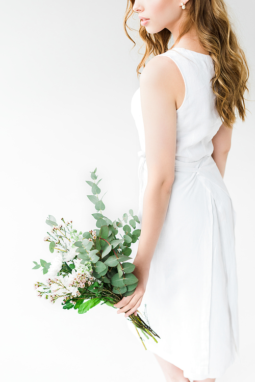 cropped view of woman in elegant dress holding flowers isolated on white