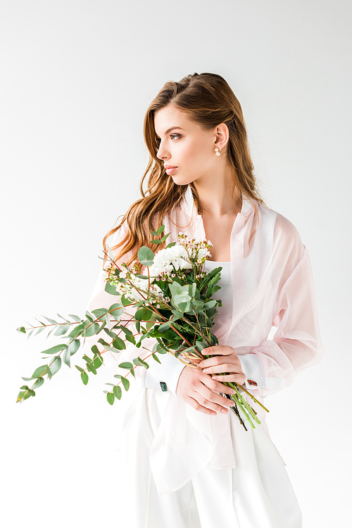 attractive girl holding flowers and green eucalyptus leaves on white