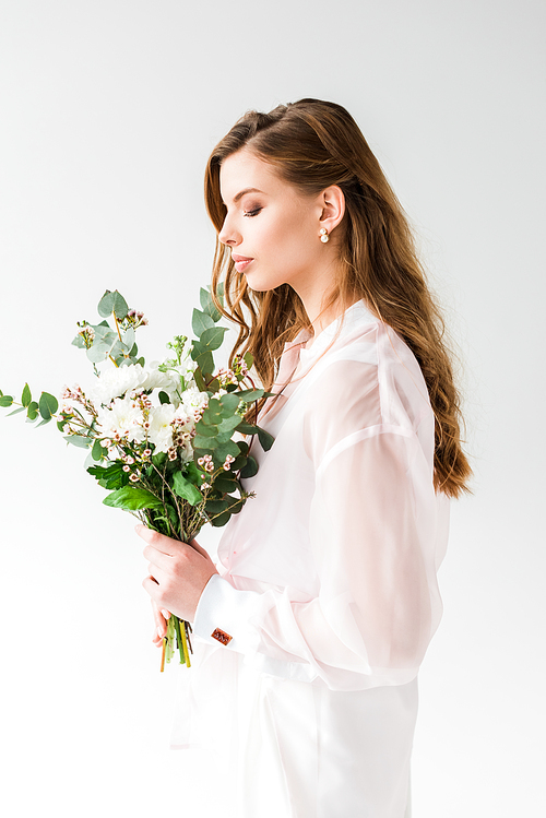 pretty girl holding flowers with green eucalyptus leaves on white