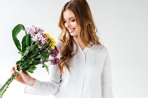 happy girl looking at bouquet of wildflowers on white