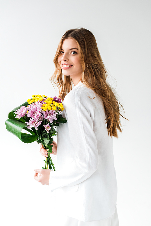 cheerful girl holding bouquet of wildflowers and smiling on white