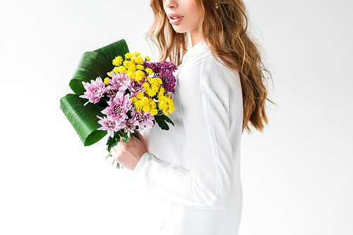 cropped view of girl holding bouquet of wildflowers on white