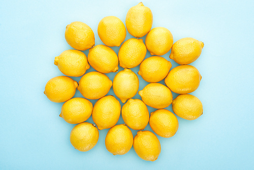 top view of ripe yellow lemons on blue background