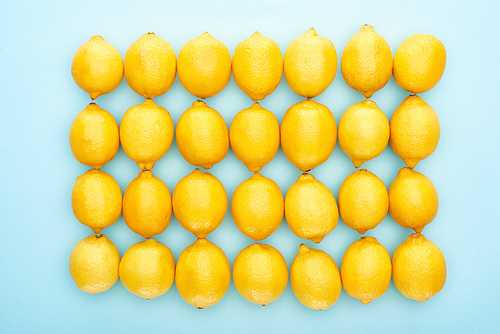 flat lay with ripe yellow lemons on blue background