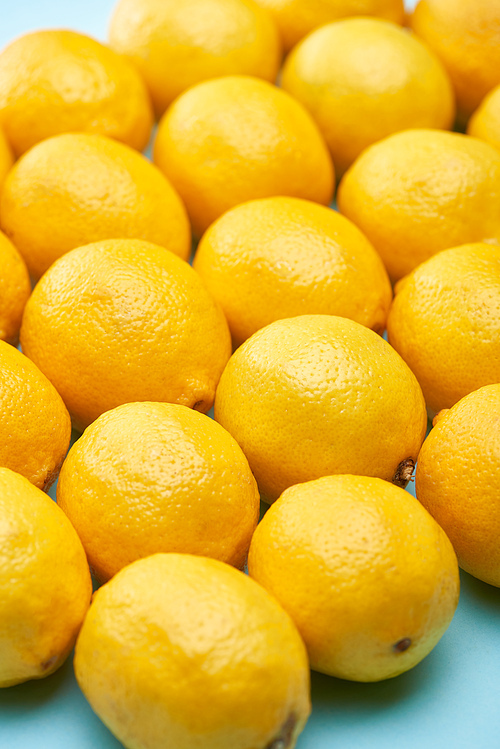 close up view of ripe yellow lemons on blue background