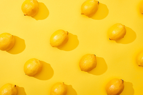 top view of ripe lemons on yellow background