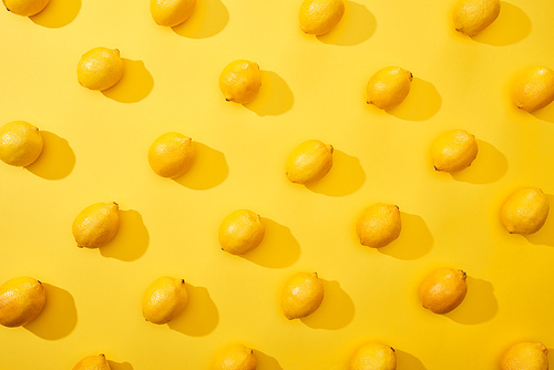 top view of ripe lemons on yellow background