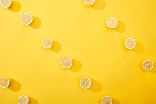 top view of ripe cut lemons on yellow background