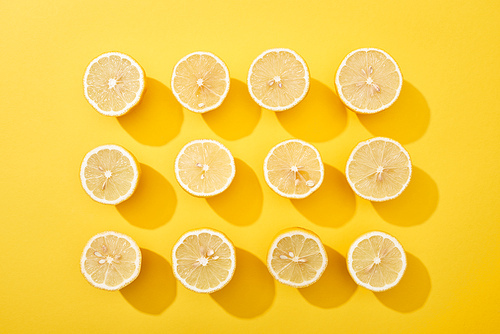 flat lay with ripe cut lemons on yellow background