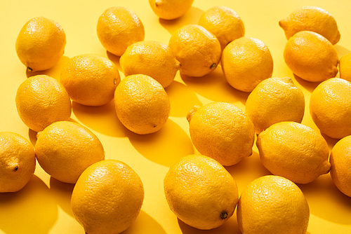 ripe whole lemons on yellow background