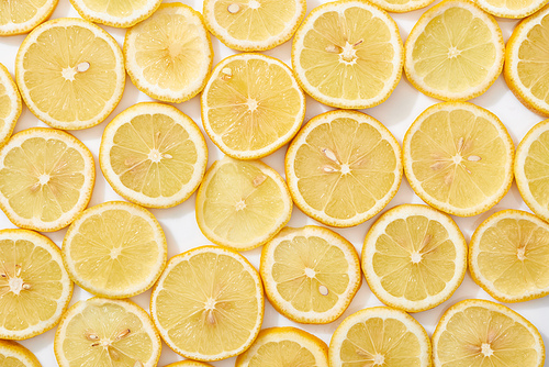top view of ripe fresh yellow lemon slices pattern on white background