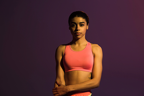 beautiful sportive african american girl in pink sports bra  isolated on purple