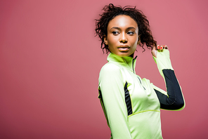 beautiful african american sportswoman in track jacket posing isolated on pink with copy space