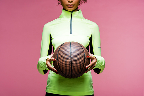 cropped view of african american sportswoman with basketball isolated on pink