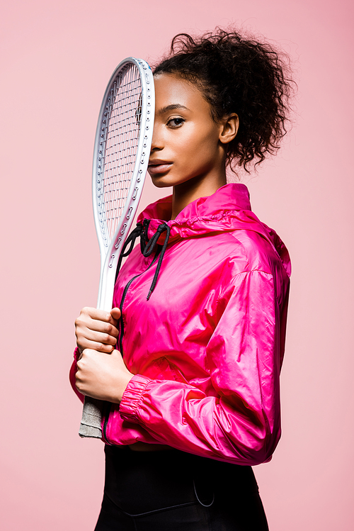 beautiful african american sportswoman holding tennis racket and  isolated on pink