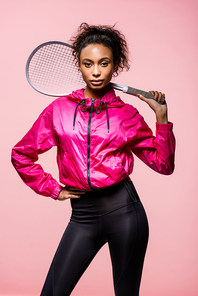 beautiful african american sportswoman holding tennis racket and  isolated on pink