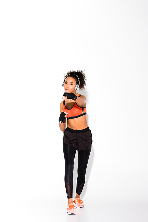 athletic african american sportswoman  and training in sport gloves on white