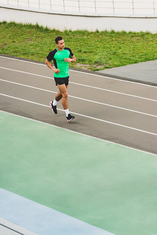 full length view of mixed race sportsman running at stadium