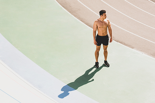 full length view of mixed race sportsman standing at stadium