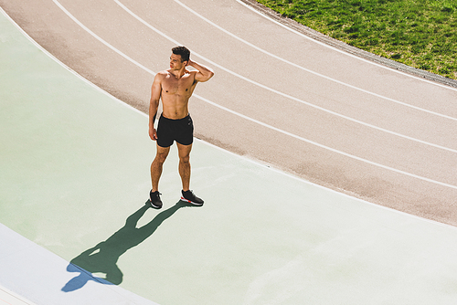 full length view of mixed race sportsman standing at stadium