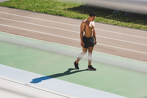 full length view of mixed race sportsman standing at stadium