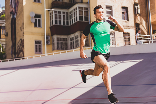 full length view of mixed race sportsman running at stadium