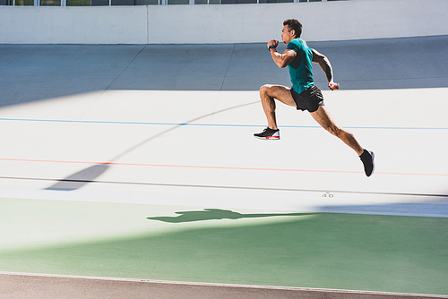 side view of mixed race sportsman running at stadium