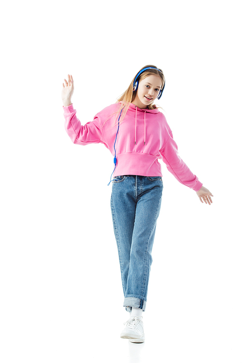 full length view of happy teenage girl in blue headphones isolated on white