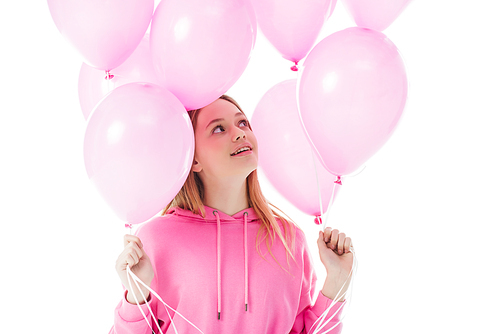 happy teenage girl looking at pink balloons isolated on white